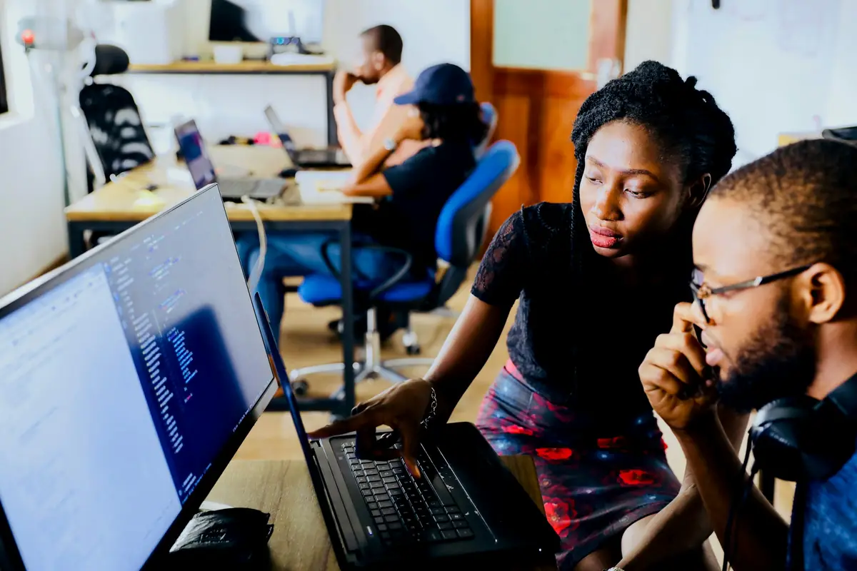 Two colleagues reviewing data together at a computer screen